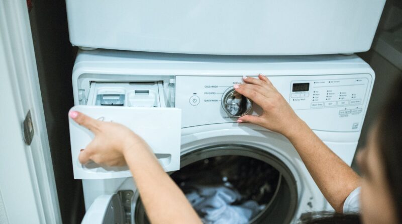 person holding white front load washing machine