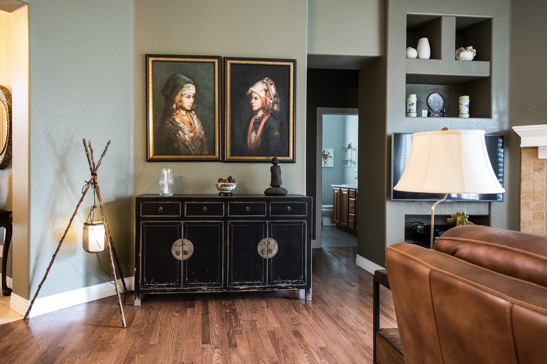 black wooden cabinet under two women paintings